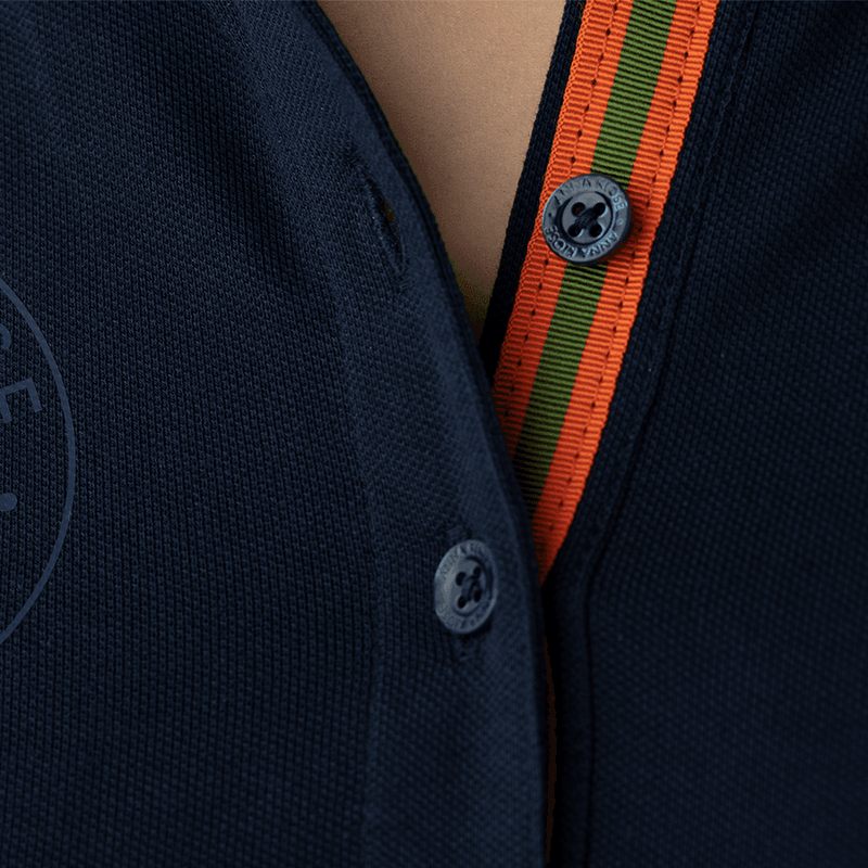 Close-up of the orange-green collar lapels of a dark-blue long-sleeved polo shirt by Anna Klose Hamburg
