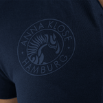 Close-up of the logo printed in blue on a dark blue long-sleeved polo shirt by Anna Klose Hamburg
