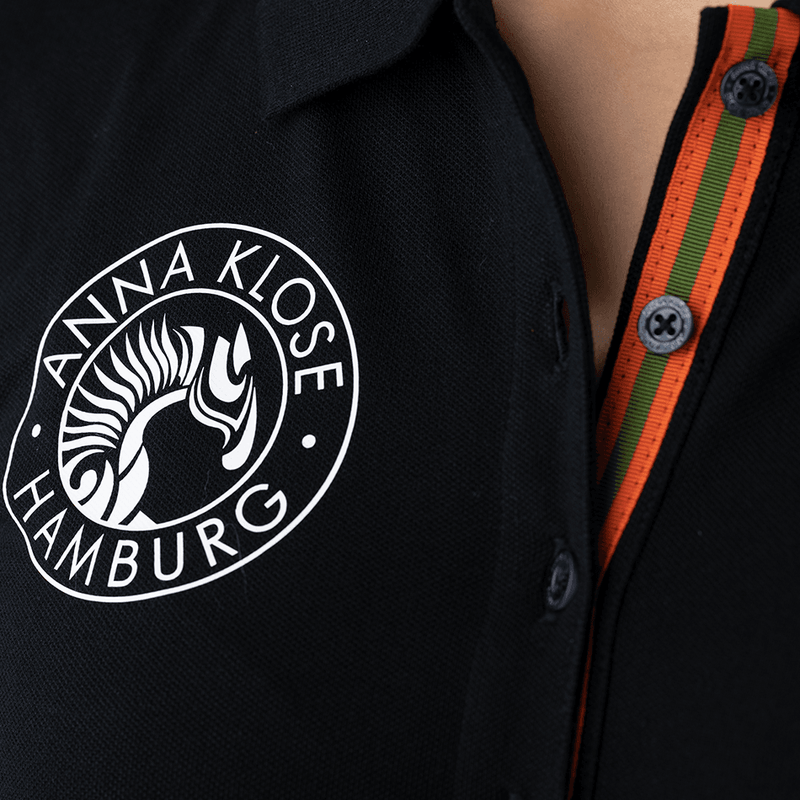 Close-up of the logo printed in white on a black polo shirt by Anna Klose Hamburg