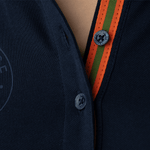 Close-up of the orange-green collar lapels of a classy dark-blue polo shirt by Anna Klose Hamburg