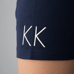 Close-up of initials personalized in gold on a dark blue polo shirt sleeve from Anna Klose Hamburg