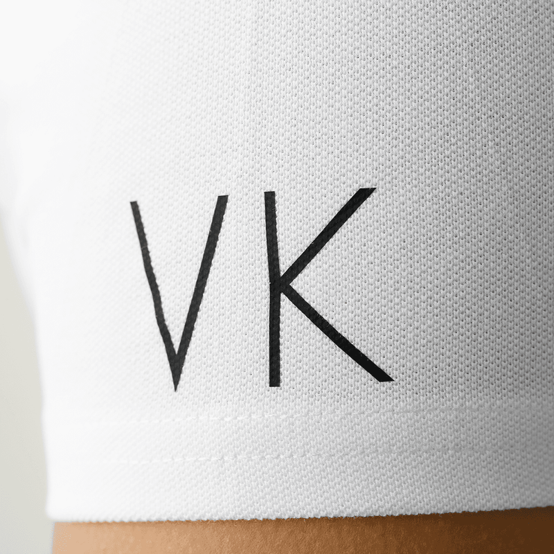 Close-up of initials personalized in black on a white polo shirt sleeve from Anna Klose Hamburg