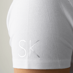 Close-up of initials personalized in silver on a white polo shirt sleeve from Anna Klose Hamburg
